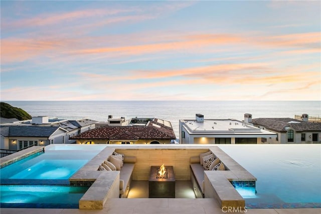 view of pool with a water view and a pool with connected hot tub