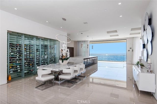 dining room with a water view, a wall of windows, and light tile patterned floors