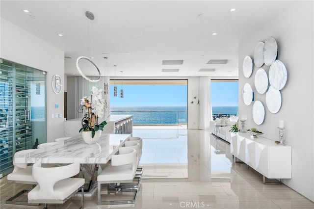 tiled dining room with a water view and expansive windows