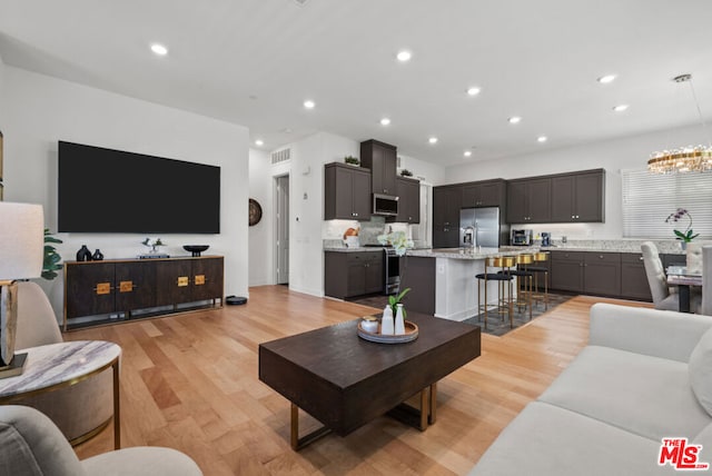 living room featuring light hardwood / wood-style flooring and a notable chandelier