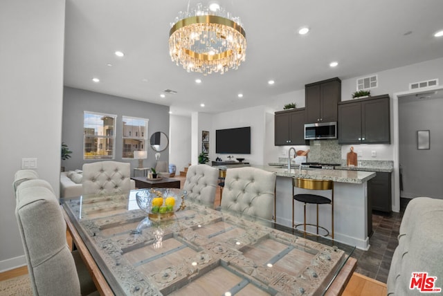 dining area with a chandelier and sink