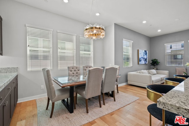 dining area featuring plenty of natural light, a notable chandelier, and light hardwood / wood-style floors