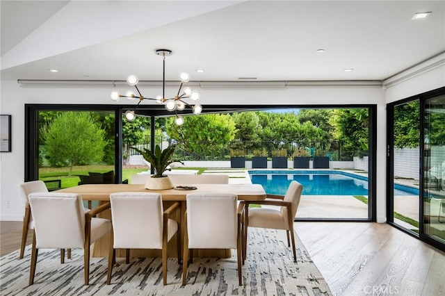 dining area featuring light hardwood / wood-style floors and a chandelier