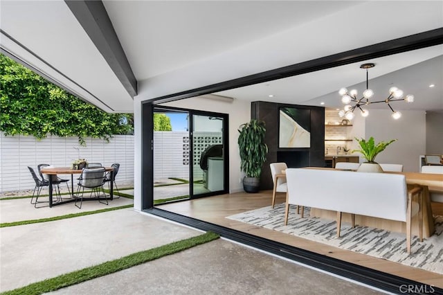 dining space with vaulted ceiling with beams and a notable chandelier