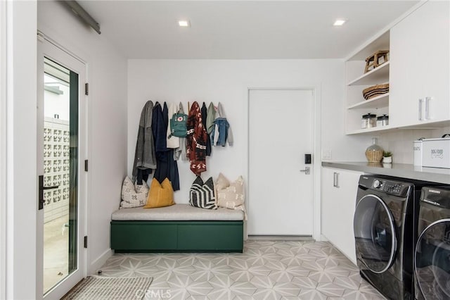 laundry room with washing machine and clothes dryer and cabinets