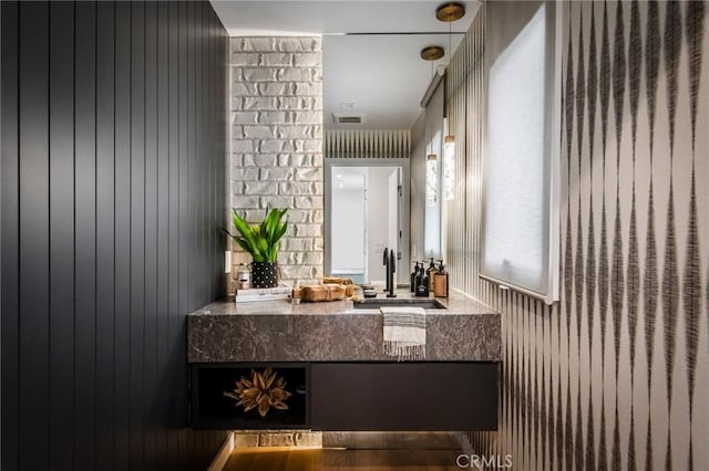 bathroom featuring wooden walls and vanity