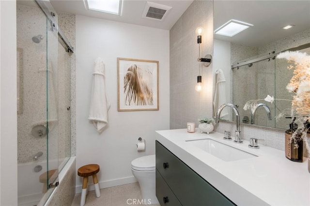 full bathroom with toilet, vanity, tasteful backsplash, tile patterned floors, and combined bath / shower with glass door