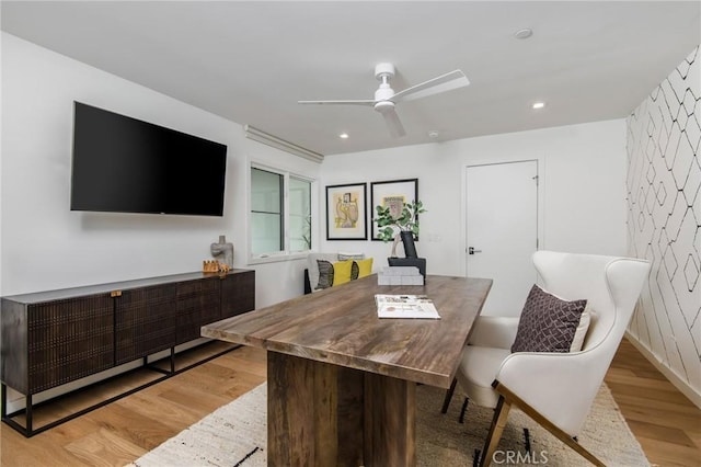 dining space with ceiling fan and light hardwood / wood-style flooring