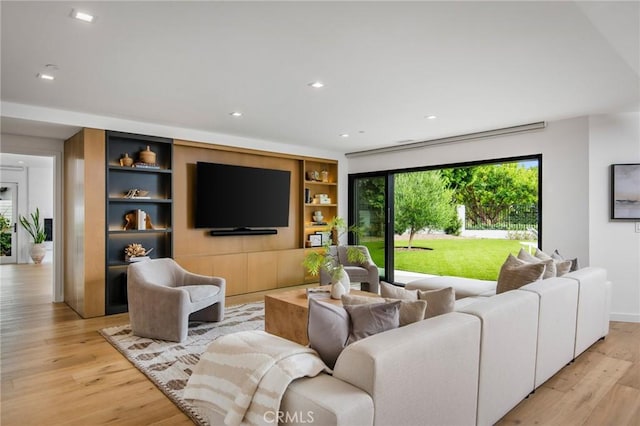 living room with light hardwood / wood-style floors and built in shelves