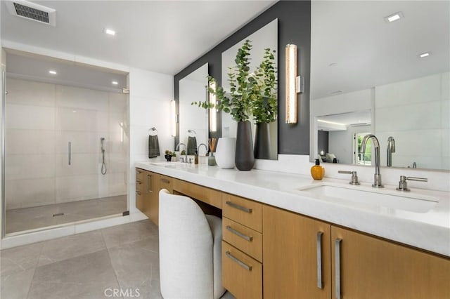 bathroom featuring a shower with shower door and vanity