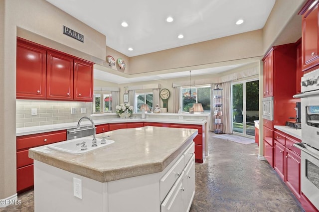 kitchen with a kitchen island, kitchen peninsula, sink, built in microwave, and double oven