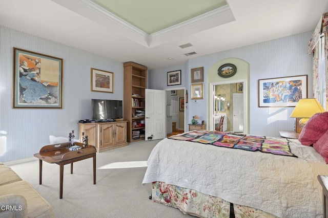 carpeted bedroom with a tray ceiling and ornamental molding