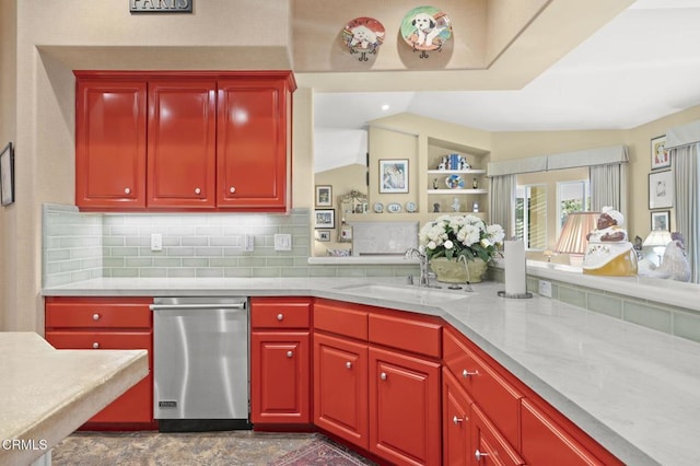 kitchen featuring lofted ceiling, dishwasher, decorative backsplash, sink, and light stone counters