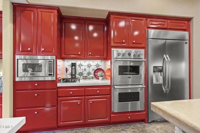 kitchen with built in appliances and tasteful backsplash