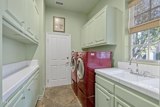 laundry room with washer and clothes dryer, sink, and cabinets