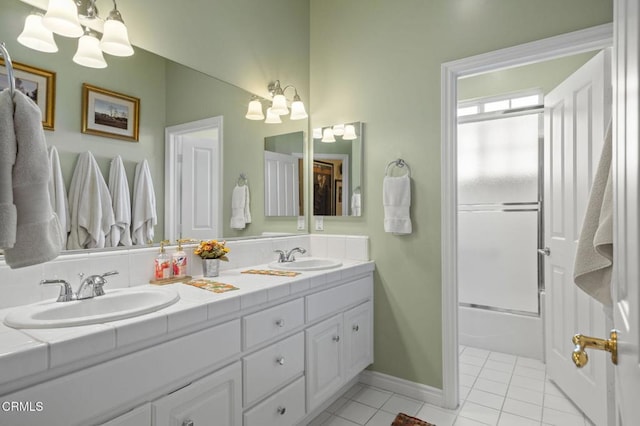 bathroom with bath / shower combo with glass door, tile patterned floors, vanity, and a chandelier