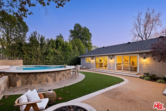 pool at dusk with a patio