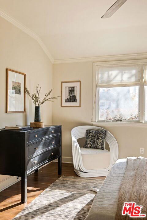 sitting room featuring vaulted ceiling, ornamental molding, and hardwood / wood-style flooring