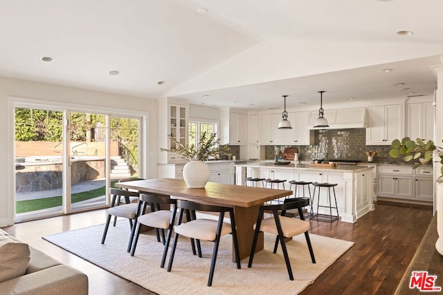 dining space featuring lofted ceiling and dark wood-type flooring