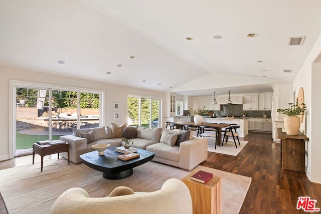 living room with dark hardwood / wood-style floors and vaulted ceiling