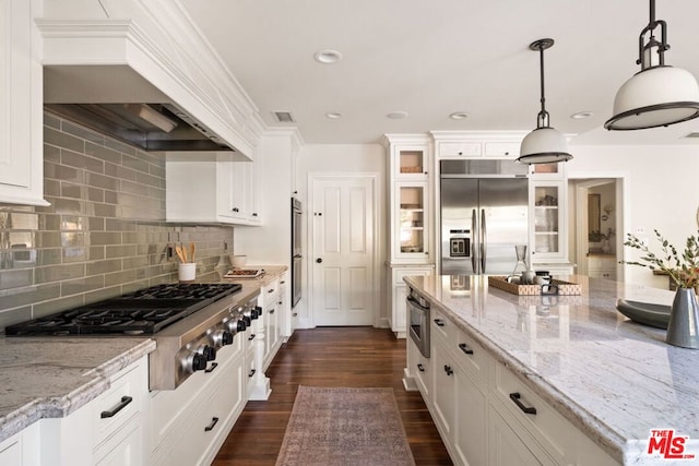 kitchen with hanging light fixtures, white cabinets, and appliances with stainless steel finishes