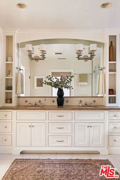 bathroom featuring vanity, tile patterned flooring, and crown molding