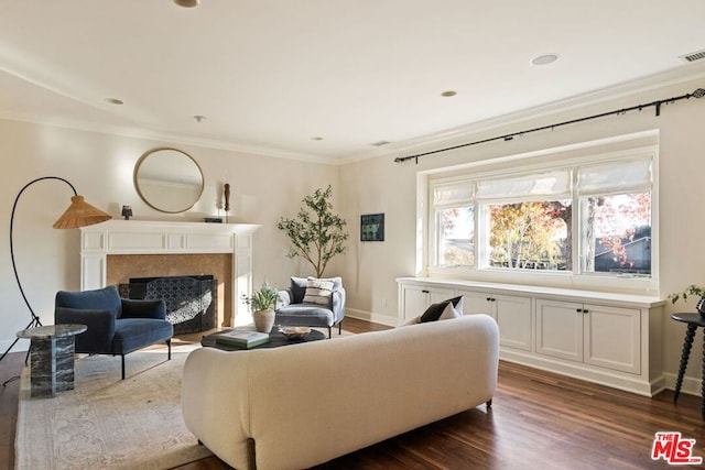 living room featuring dark wood-type flooring, a high end fireplace, and ornamental molding