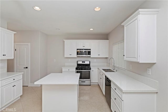 kitchen with white cabinets, a center island, stainless steel appliances, sink, and light tile patterned floors