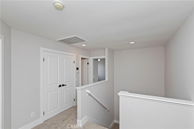 hallway with light colored carpet