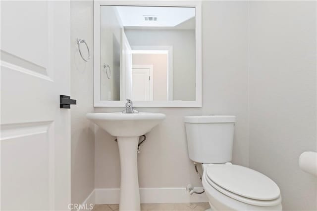 bathroom with toilet and tile patterned flooring