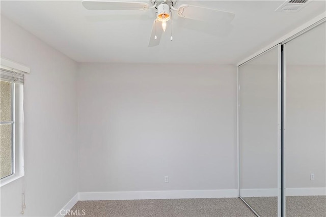 unfurnished bedroom featuring ceiling fan, a closet, and carpet