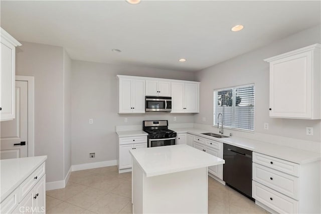 kitchen with appliances with stainless steel finishes, white cabinetry, a kitchen island, and sink