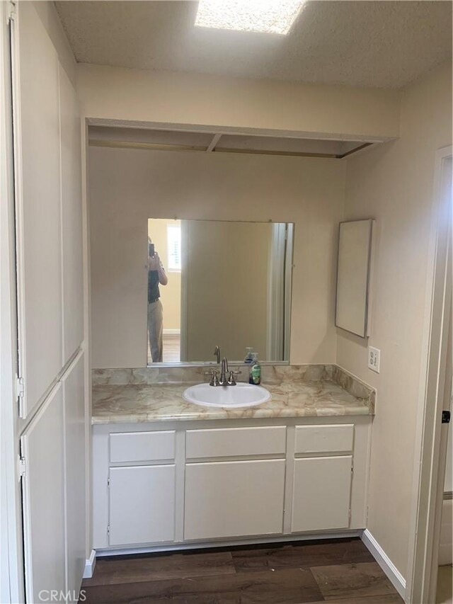 21834 Belshire Ave Unit 2, Hawaiian Gardens, CA 90716 - bathroom featuring vanity, wood finished floors, and baseboards