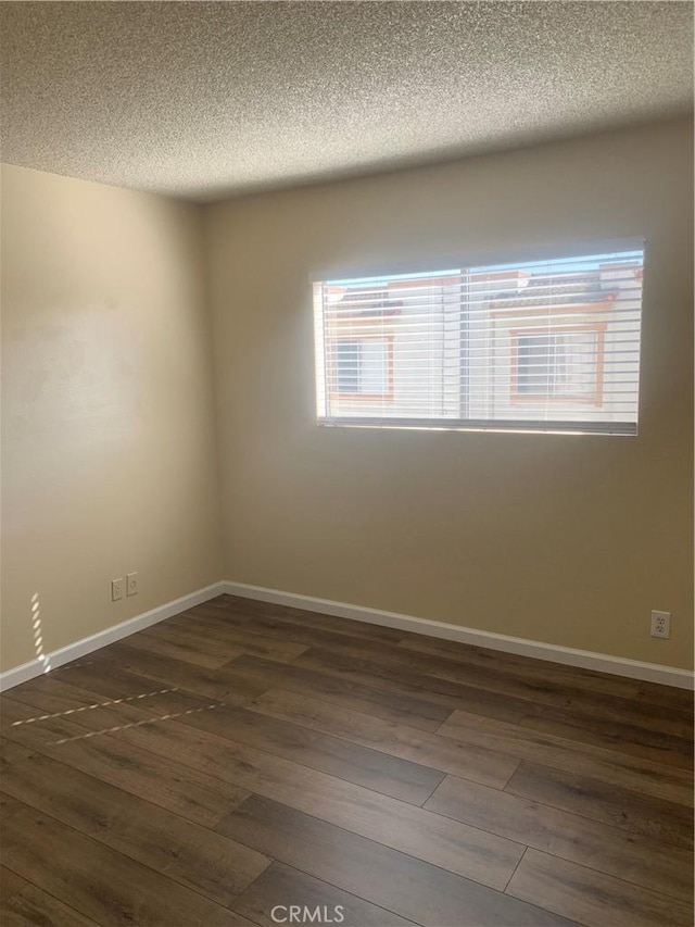 21834 Belshire Ave Unit 2, Hawaiian Gardens, CA 90716 - spare room featuring dark wood-type flooring, baseboards, and a textured ceiling