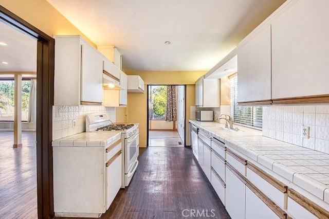 kitchen featuring white cabinetry, white range with gas cooktop, and tile counters