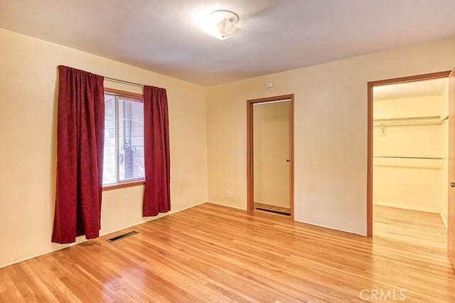 unfurnished bedroom with a closet and light wood-type flooring