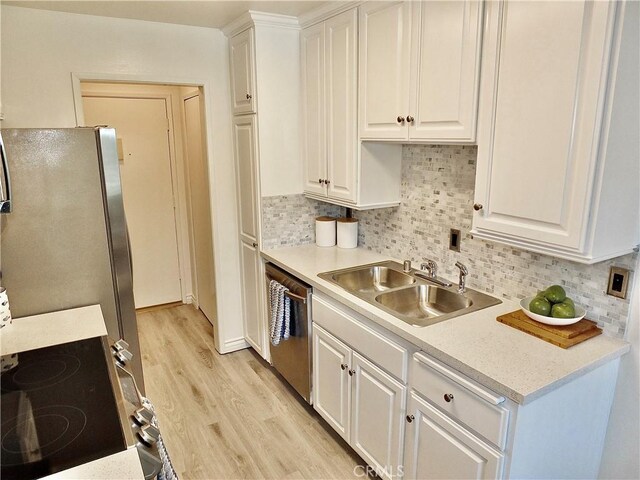 kitchen featuring stainless steel appliances, white cabinets, tasteful backsplash, and sink