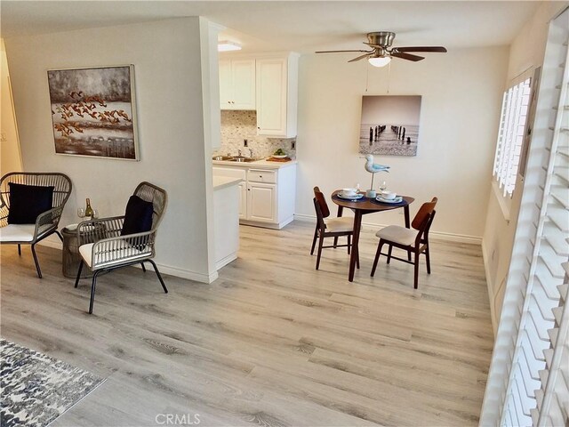 dining space featuring sink, ceiling fan, and light hardwood / wood-style floors