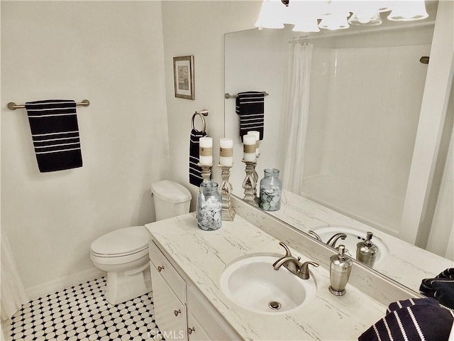 bathroom featuring toilet, tile patterned floors, vanity, and curtained shower