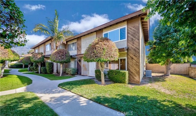 view of front of property with a front lawn and central AC unit