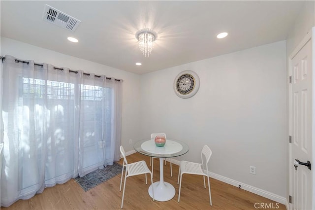 dining space with a notable chandelier and hardwood / wood-style floors