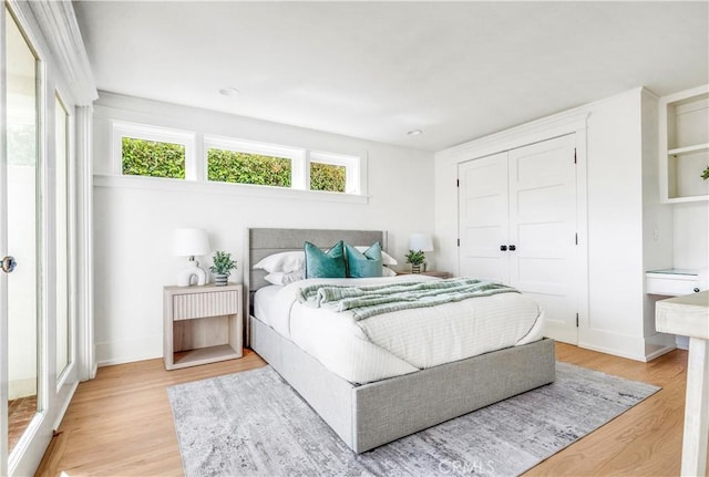 bedroom with light hardwood / wood-style flooring and a closet