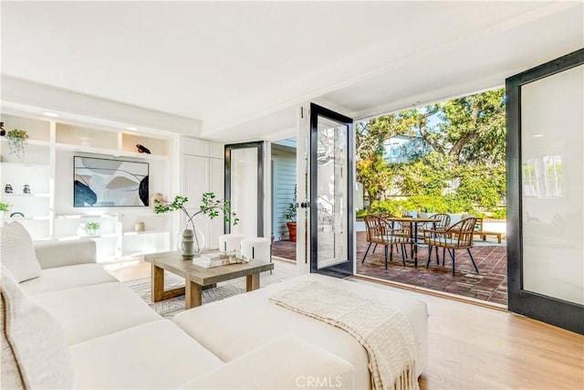 bedroom featuring access to exterior, hardwood / wood-style floors, a wall of windows, and french doors