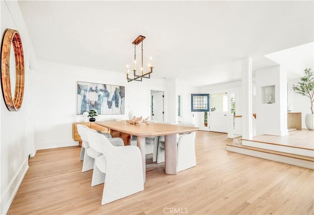 unfurnished dining area featuring light hardwood / wood-style floors and a notable chandelier