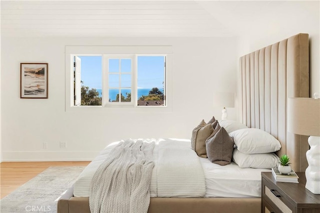 bedroom featuring multiple windows, light hardwood / wood-style flooring, and wood ceiling