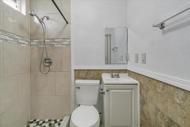 bathroom with vanity, tiled shower, and toilet