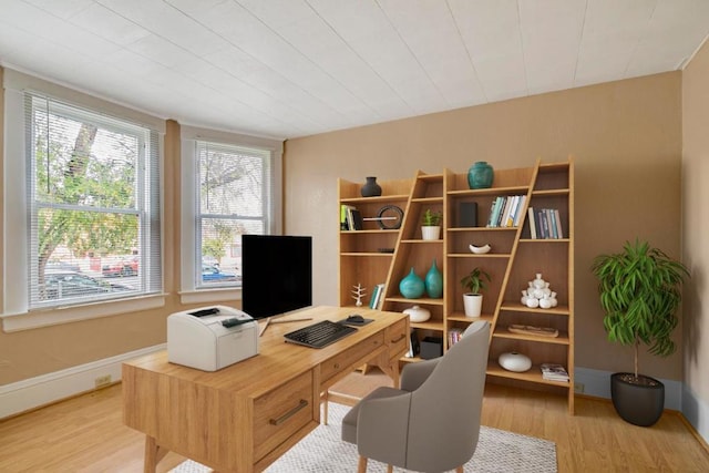 office with light hardwood / wood-style flooring and plenty of natural light