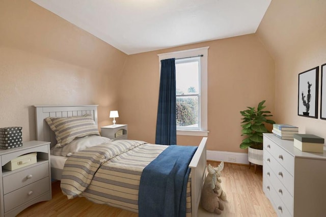 bedroom with lofted ceiling and light hardwood / wood-style floors