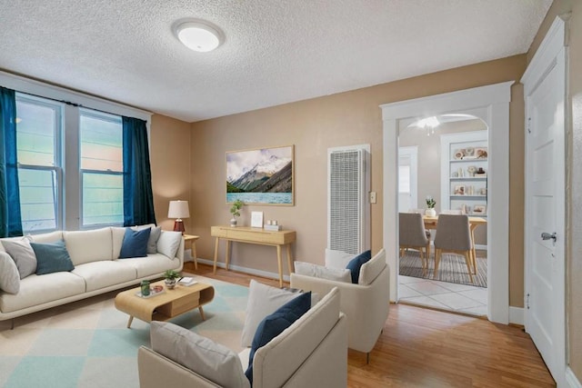 living room featuring a textured ceiling and light hardwood / wood-style floors