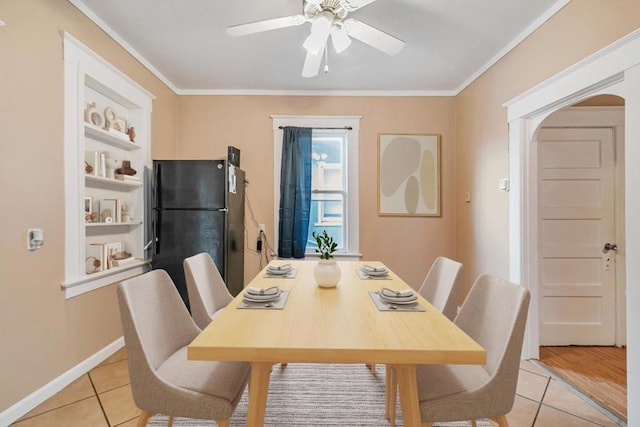 tiled dining room with crown molding, ceiling fan, and built in shelves